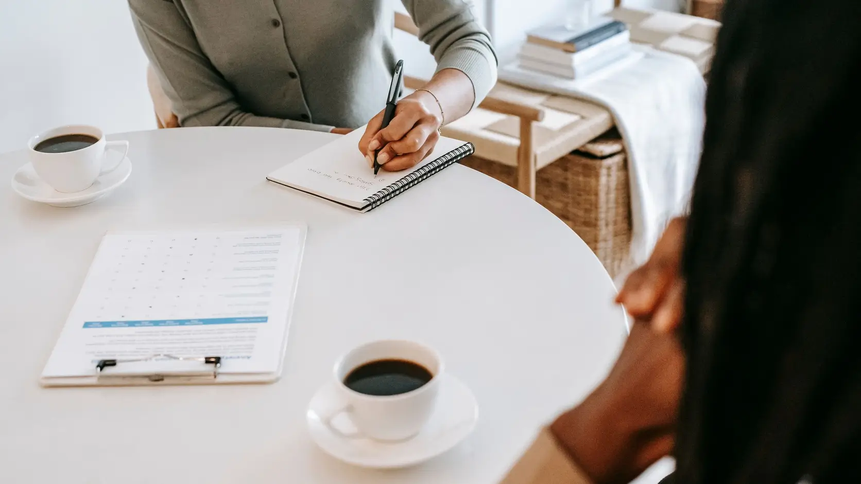 Researcher taking notes during a qualitative interview