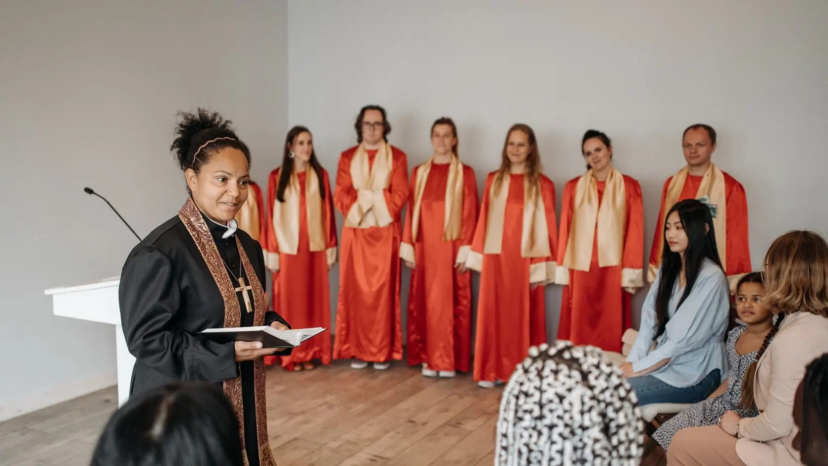 Pastor speaking with a choir and congregation during a church service