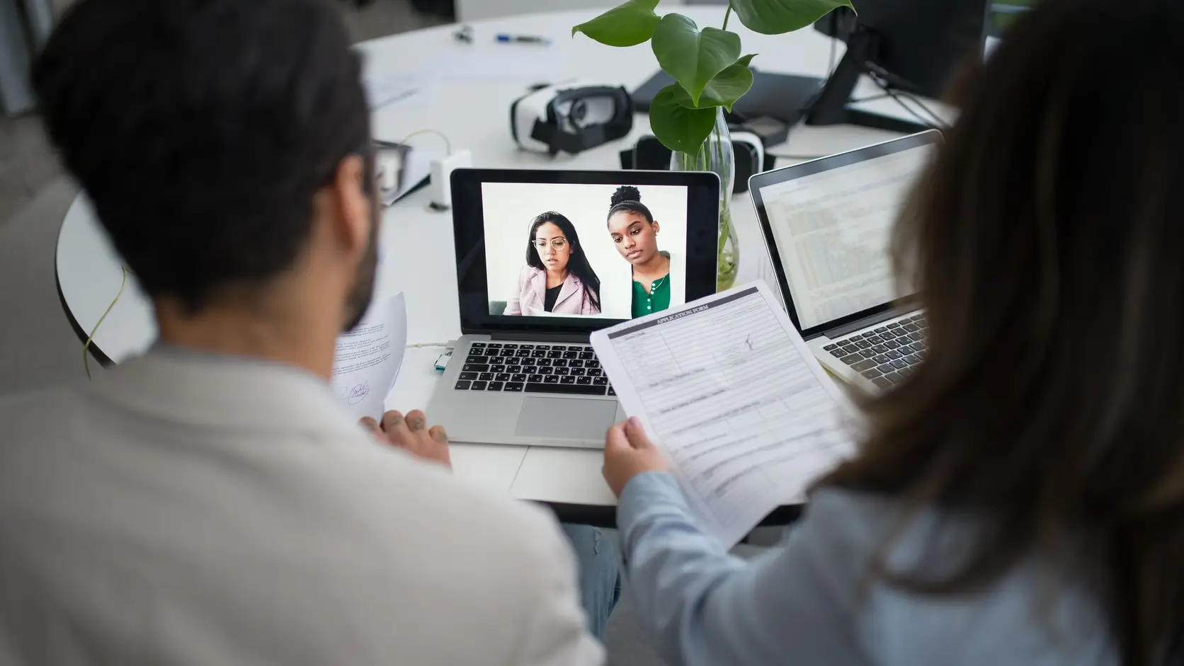 Remote team meeting recording reviewed with laptops and documents